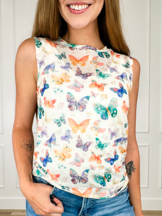 Sleeveless sheer mesh tank top with vibrant butterfly print, close-up of front neckline