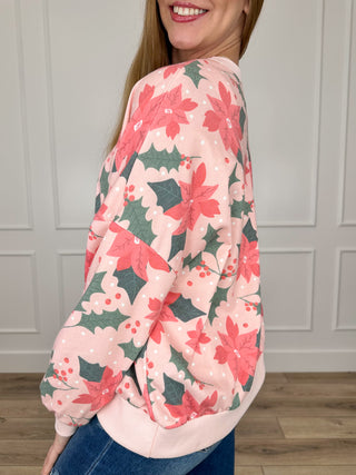 Pink knit long-sleeve top with poinsettia floral print, side view