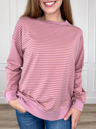 Pink striped long-sleeve top with crew neck and ribbed cuffs