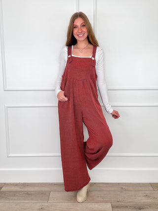 Wine red ribbed overalls with square neckline bib, adjustable straps, relaxed wide-leg fit