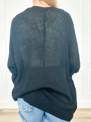 Back view of dark textured knit long-sleeve cardigan with wide drape.