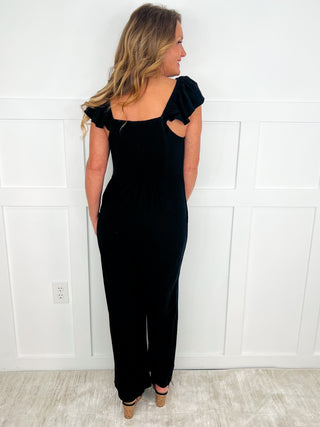 Black cotton Avery Mae jumpsuit, back view with ruffled cap sleeves and wide legs