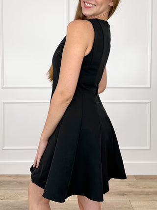 Black sleeveless fit-and-flare dress, angled side view with flared skirt