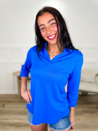 Lightweight 3/4 sleeve V-neck top in blue, worn with denim shorts.