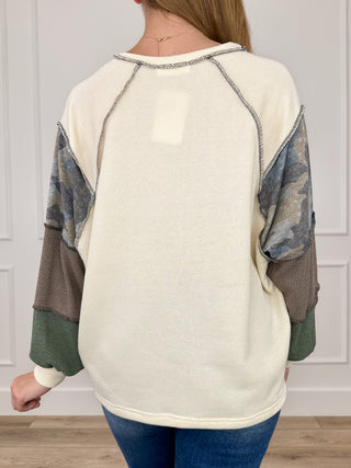 Cream knit long-sleeve top back view with camo raglan sleeves and rounded neckline
