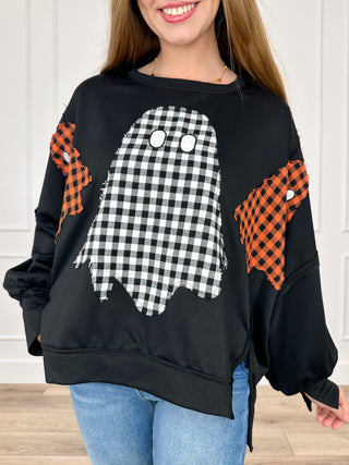 Black long-sleeve top with front graphic and orange plaid sleeve panels.