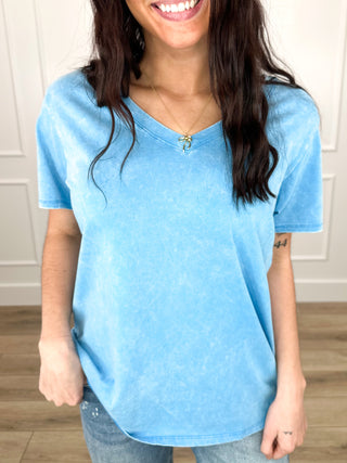 Magenta/pink V-neck short-sleeve cotton top with relaxed fit and curved hemline.