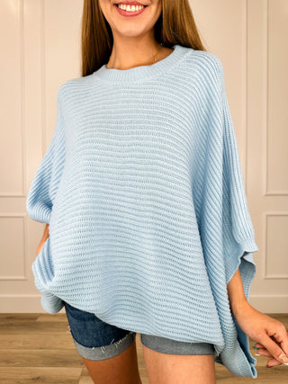 Light blue knit poncho top with crew neckline and flowy 3/4 dolman sleeves