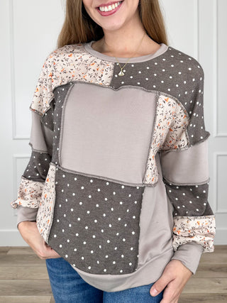 Brown knit long-sleeve colorblock top with polka-dot and floral print sleeves, crew neck
