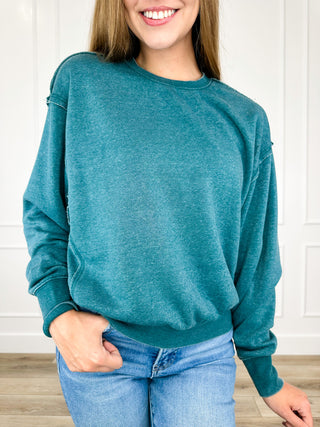 Teal crewneck sweatshirt with long sleeves and ribbed cuffs