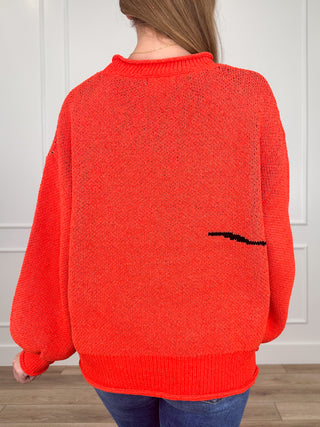 Orange knit long-sleeve sweater back view with small ghost graphic