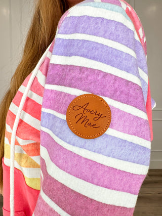 Multicolor striped sleeve hoodie with brown Avery Mae logo patch on shoulder