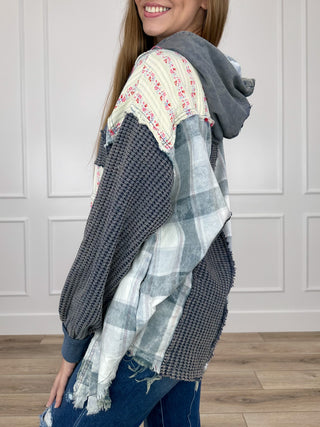 Charcoal hooded long-sleeve top with drawstring and patchwork sleeve panels, side view