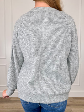 Grey knit cardigan back view with long sleeves and ribbed hem