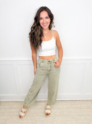 Women's white crop tank and light olive cargo pants with open-toe sandals