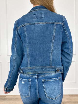 Dark wash cropped denim jacket with back yoke, long sleeves, and belt at back hem