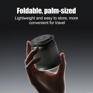 Black foldable palm-sized wireless charging puck held in hand