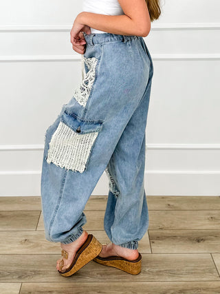 Back view of light denim blue cotton cargo joggers with elastic cuffs and patch cargo pockets.
