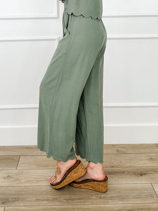 Green high-rise wide-leg pants with elastic waist and scalloped cuffs