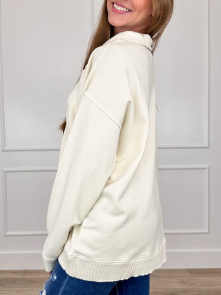 Cream cotton long-sleeve pullover sweatshirt, side view, ribbed hem and cuffs