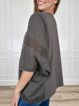 Grey short sleeve top with perforated side and sleeve mesh paneling, relaxed fit