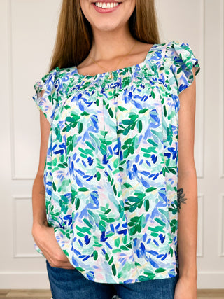 Rayon blend cap-sleeve top with blue and green leaf print, ruffled shoulders