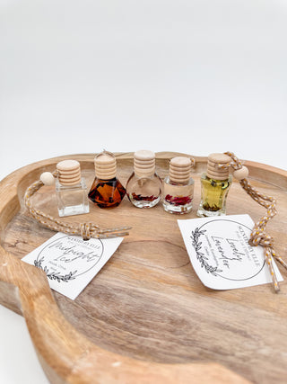 Scent diffuser bottle set with cork caps, rope cords, and scent labels on a wooden tray