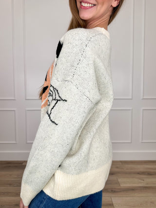 Cream knit long-sleeve sweater with jack-o-lantern and spiderweb graphic on sleeve