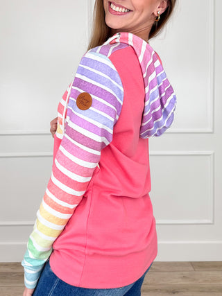 Multicolor striped half-zip hoodie with bright pink side panels and drawstring hood