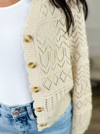Cream knit cardigan with button-front detail and diamond texture, long sleeves