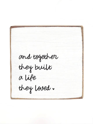 Wood block sign with quote: "and together they built a life they loved".