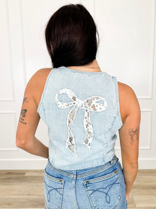 Light wash denim vest back with large lace bow detail and button closure