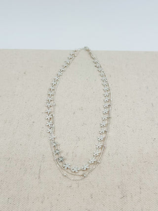 Silver teardrop charm necklace with star-like links and layered chain