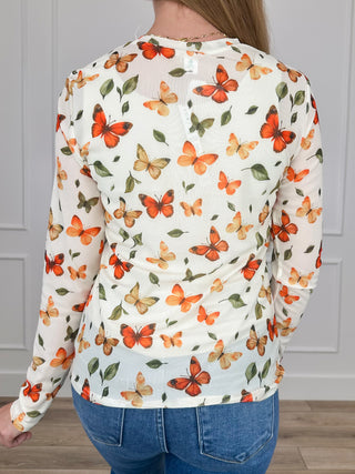 Back of cream sheer mesh long-sleeve top with butterfly floral print and curved hem