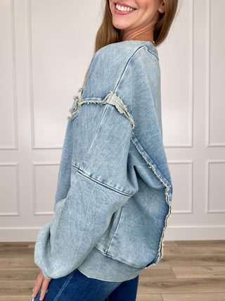 Blue long-sleeve cotton-blend top with distressed seams and raw-edge detail