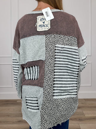 Grey patchwork long-sleeve top with brown, striped blocks and pocket detail