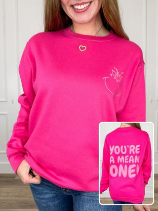 Pink crewneck sweatshirt with long sleeves and 'You're a Mean One' graphic