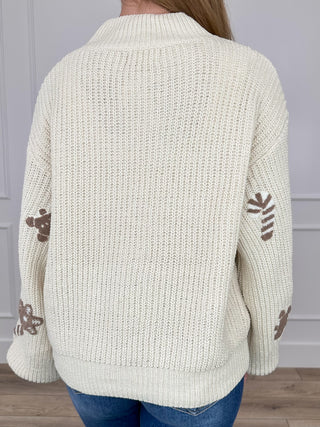 Cream knit mock-neck cropped sweater with ribbed hem and cuffs, gingerbread cookie print