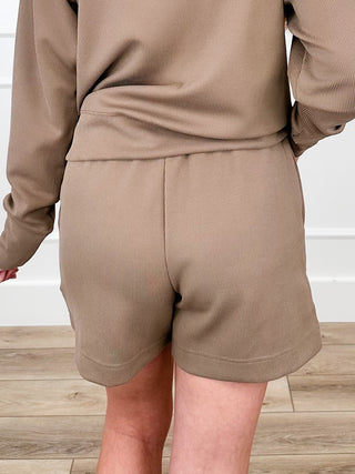 High-rise ribbed shorts in taupe, back view with fitted ribbed texture.