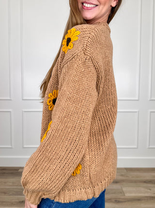 Tan knit long-sleeve cardigan with yellow sunflower applique on sleeves