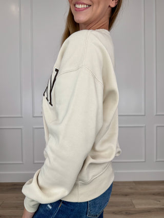 Cream crewneck long-sleeve sweatshirt shown from the side