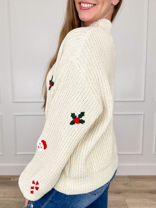 Cream cropped knit sweater with holiday character prints and ribbed mock neck