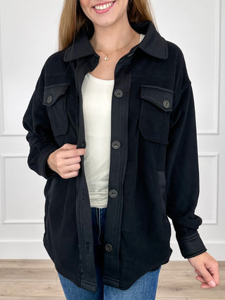 Black long-sleeve button-up shacket with chest flap pockets and snap buttons