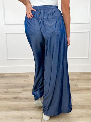 Blue high-rise wide-leg pants with gathered elastic waistband and relaxed straight legs