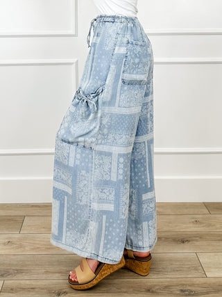 Blue high-rise wide-leg cargo pants with elastic waist, patchwork print, and side pockets