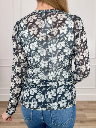 Back view: black sheer mesh long-sleeve top with white floral print