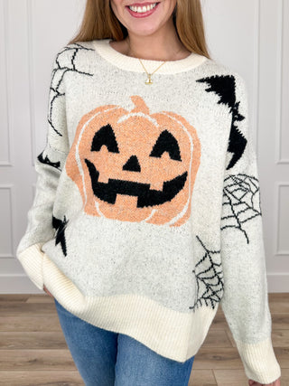 Cream knit long-sleeve sweater top with jack-o-lantern and spiderweb graphics
