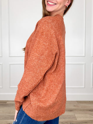 Rust orange knit mock-neck sweater top with long sleeves, side view