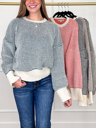Blue-and-white textured knit long-sleeve sweater with ribbed cuffs, hem, and buttoned neckline.