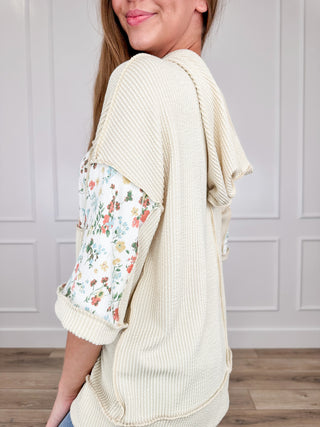 Cream ribbed hooded short sleeve top with floral patch pocket and sleeve cuffs